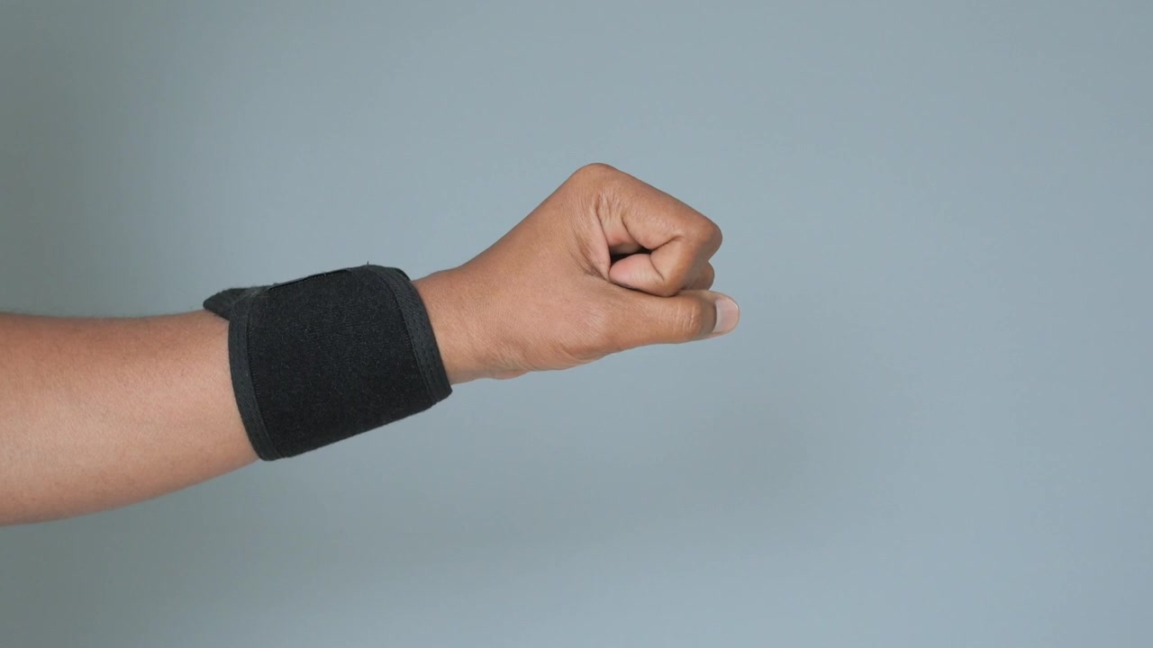 Nahaufnahme einer Hand mit Handgelenkstütze beim Anspannen und Entspannen