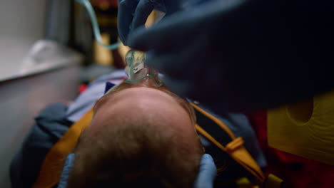 paramedics putting oxygen mask on patient. medical assistants rescuing victim