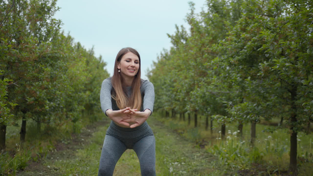 mujer estirándose en el huerto de manzanas
