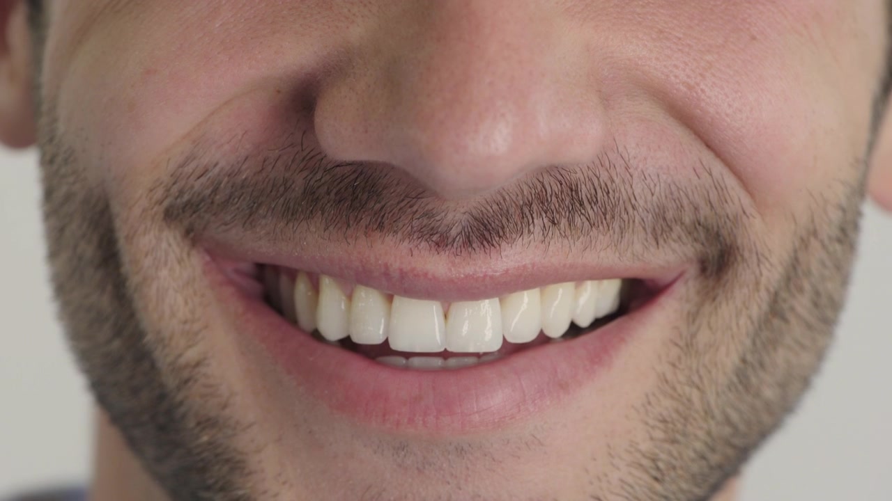 Primo piano di un giovane uomo che sorride