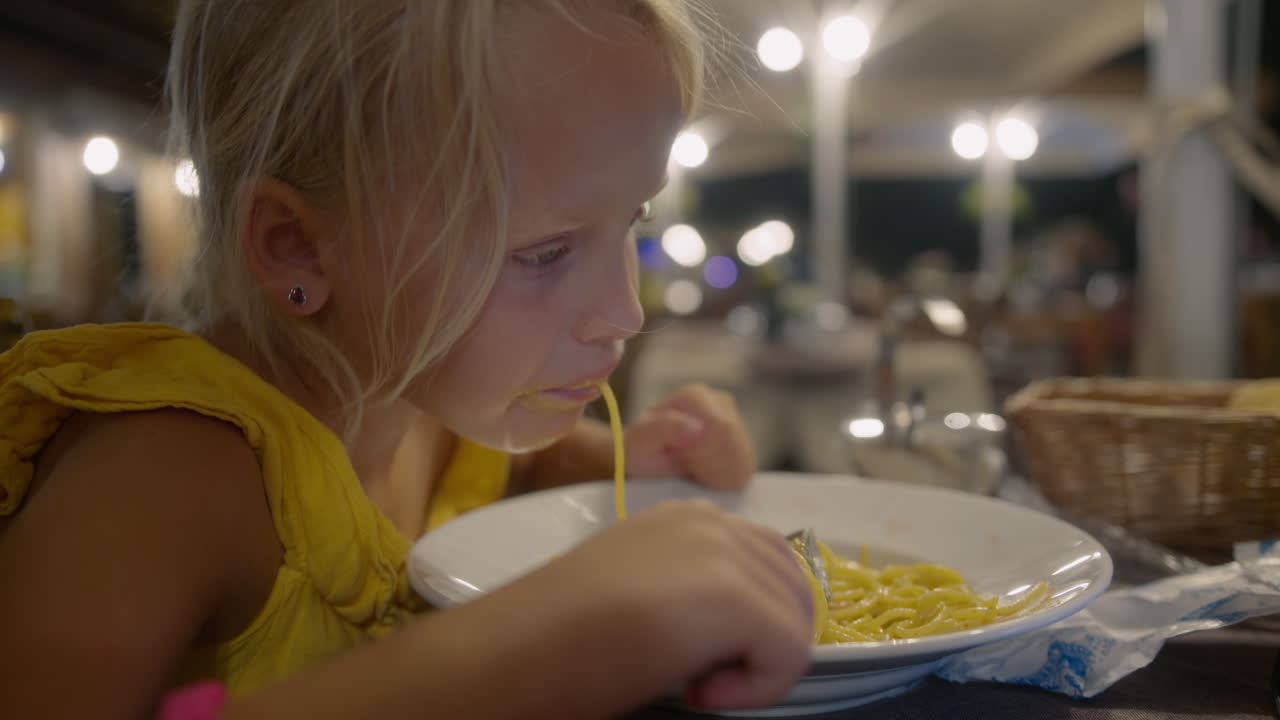 Giovane ragazza che gusta un piatto di spaghetti