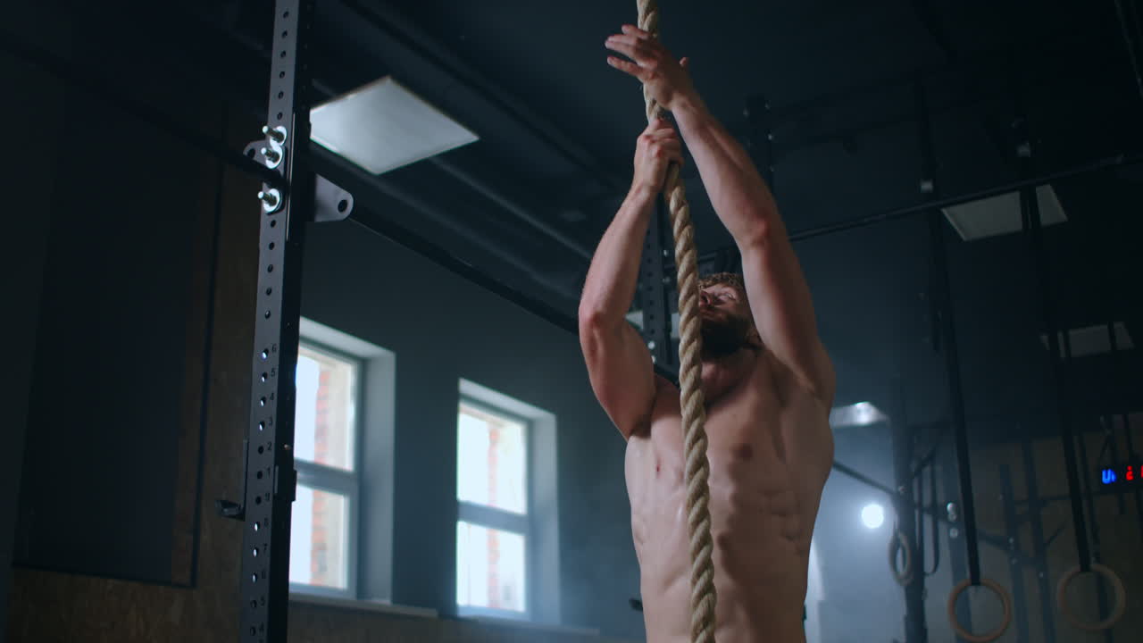 hombres fuertes durante el entrenamiento suben la cuerda a la cima. entrenamiento para rescatistas. ejercicio de resistencia y coordinación.