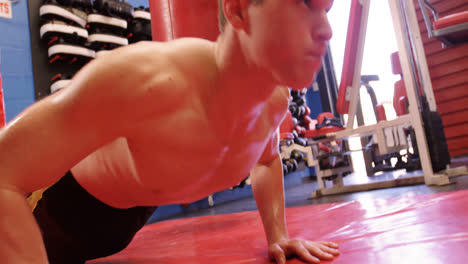 un boxeador sin camisa haciendo flexiones