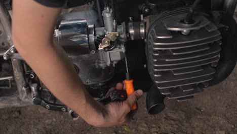 the mechanic man tunes the engine, mechanic fixes old motorcycle engine