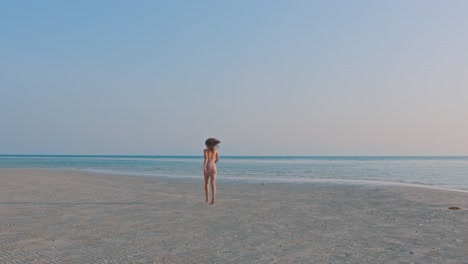 woman walking on a beach at sunset