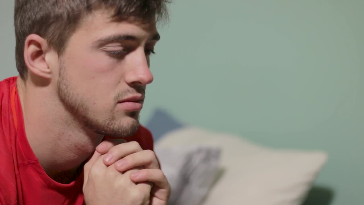 Plano médio fechado de um homem olhando fixamente para a frente, com expressão confusa.
