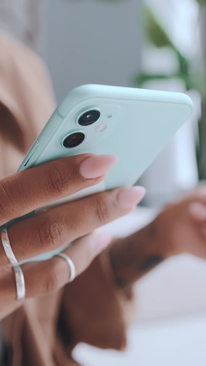 Persona che usa uno smartphone per chattare o navigare in uno spazio interno luminoso