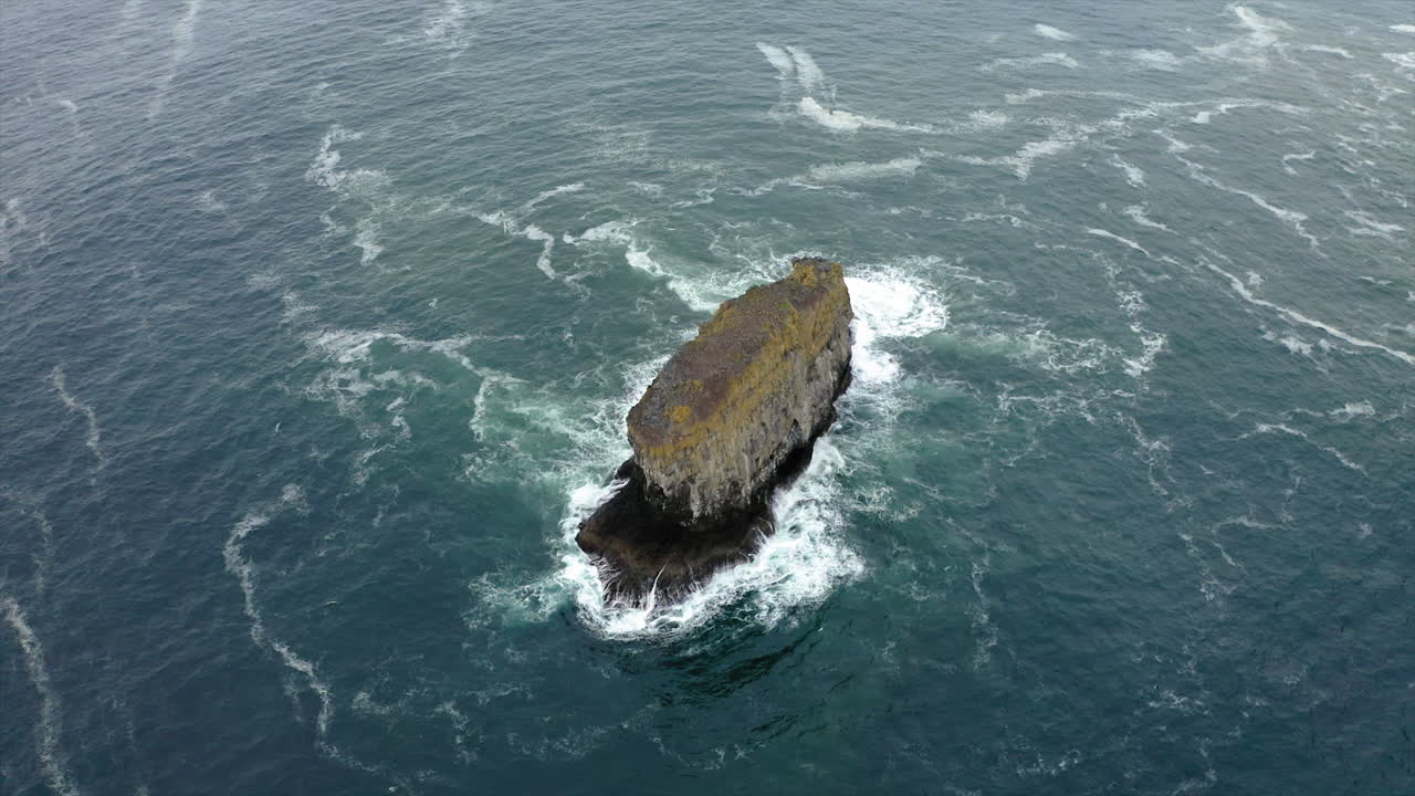 Aerial View of a Solitary Sea Stack in Rough Ocean Waters