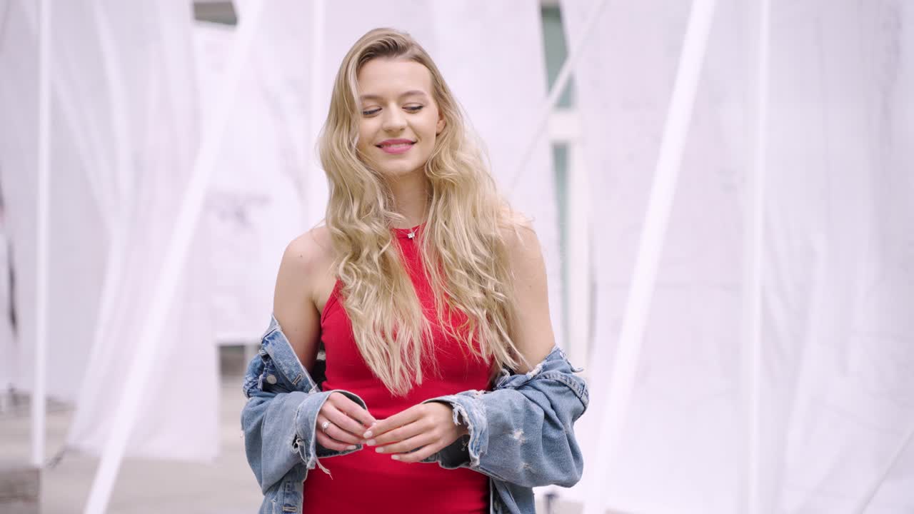 mujer con vestido rojo y chaqueta de vaqueros