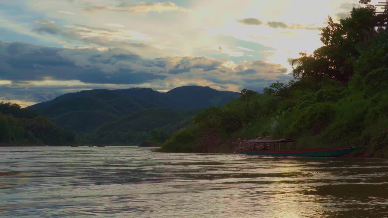 메콩 강에서 꿈 같은 해가 지고, 전통적인 보트 파크가 에, 언덕이 배경입니다.