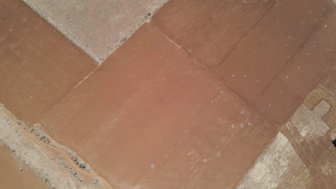 antena de arriba hacia abajo de campos áridos y revelando una pista de aterrizaje abandonada en la zona rural de kenia