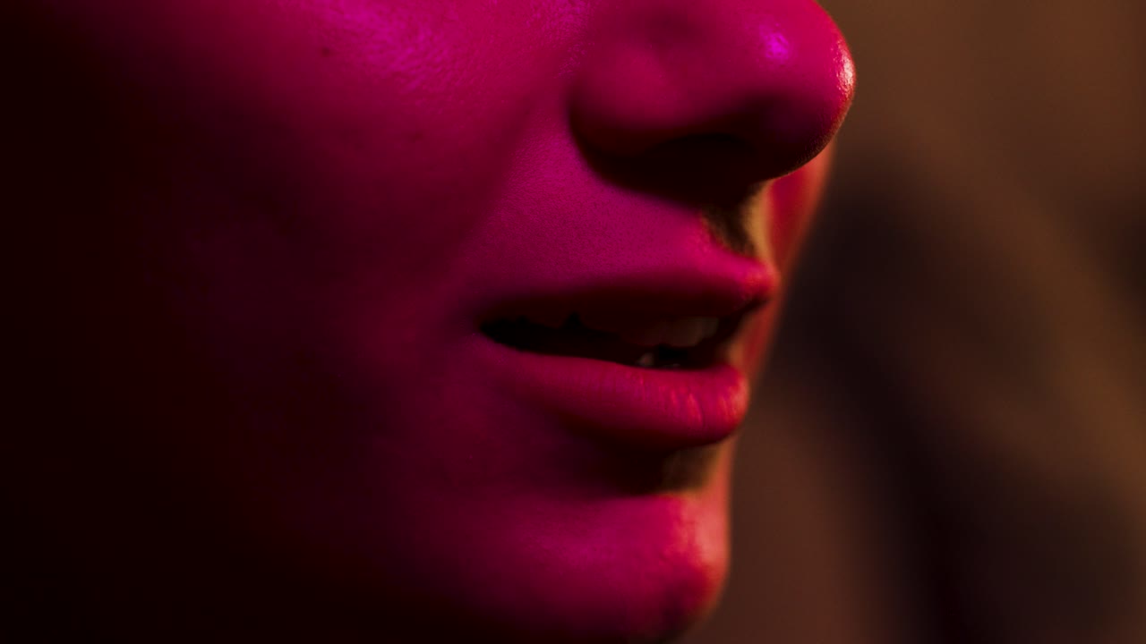 mujer dice 'wow' reaccionando a una pantalla de cine iluminada por el cambio de color de la luz