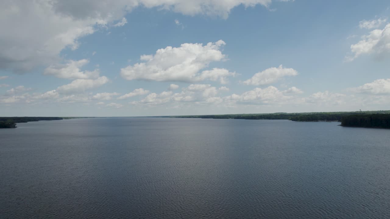 Magnificent sunny day with blue sky and clouds on lake.