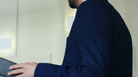 close-up view of caucasian businessman speaker on a podium wearing formal clothes and talking in a conference room