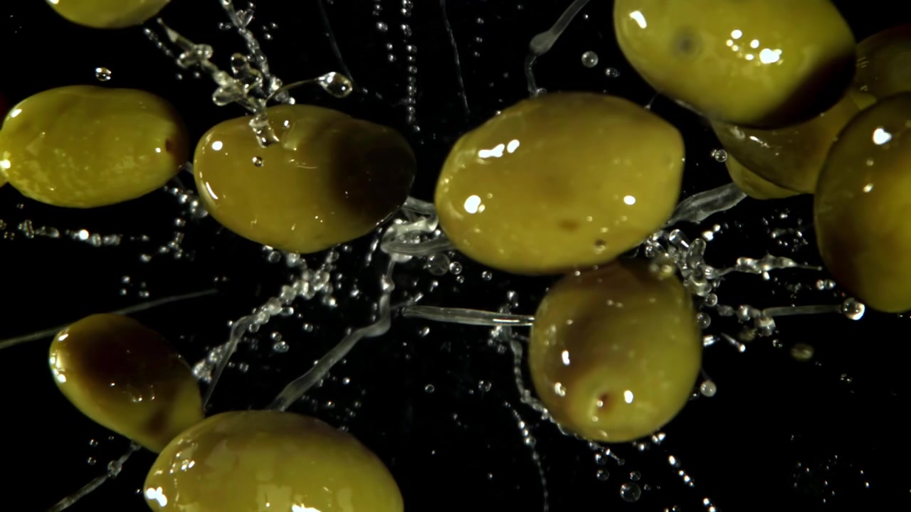 Olive verdi fresche che schizzano in acqua al rallentatore