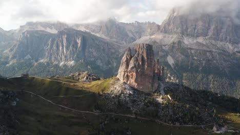 cinque torri bathed in sunlight surrounded by rugged mountain ranges