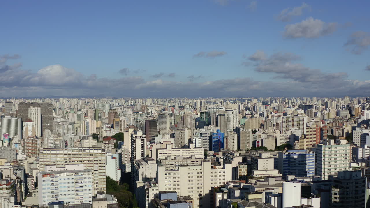 alejar a dolly en una impresionante toma de paisaje urbano con drones de una gran metrópolis en un día soleado de cielo azul