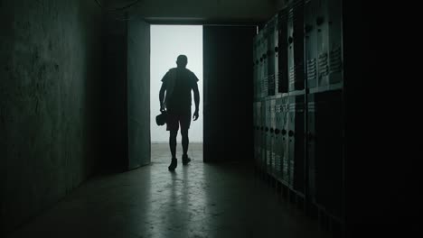 back view young shirtless muscular caucasian man hitting locker with his fist, tired and upset after failure in gym