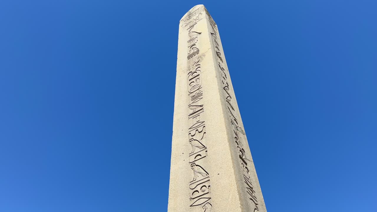 Tall obelisk tower with egyptian hieroglyphs near Suleymaniye Mosque, orbital