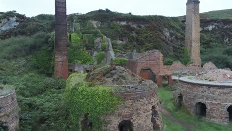 Porth-Wen-Luftaufnahme-Niedrig-Bis-Hoch-Verlassene-Viktorianische-Industrielle-Mauerwerksfabrik-Bleibt-An-Der-Erodierten-Küste-Von-Anglesey