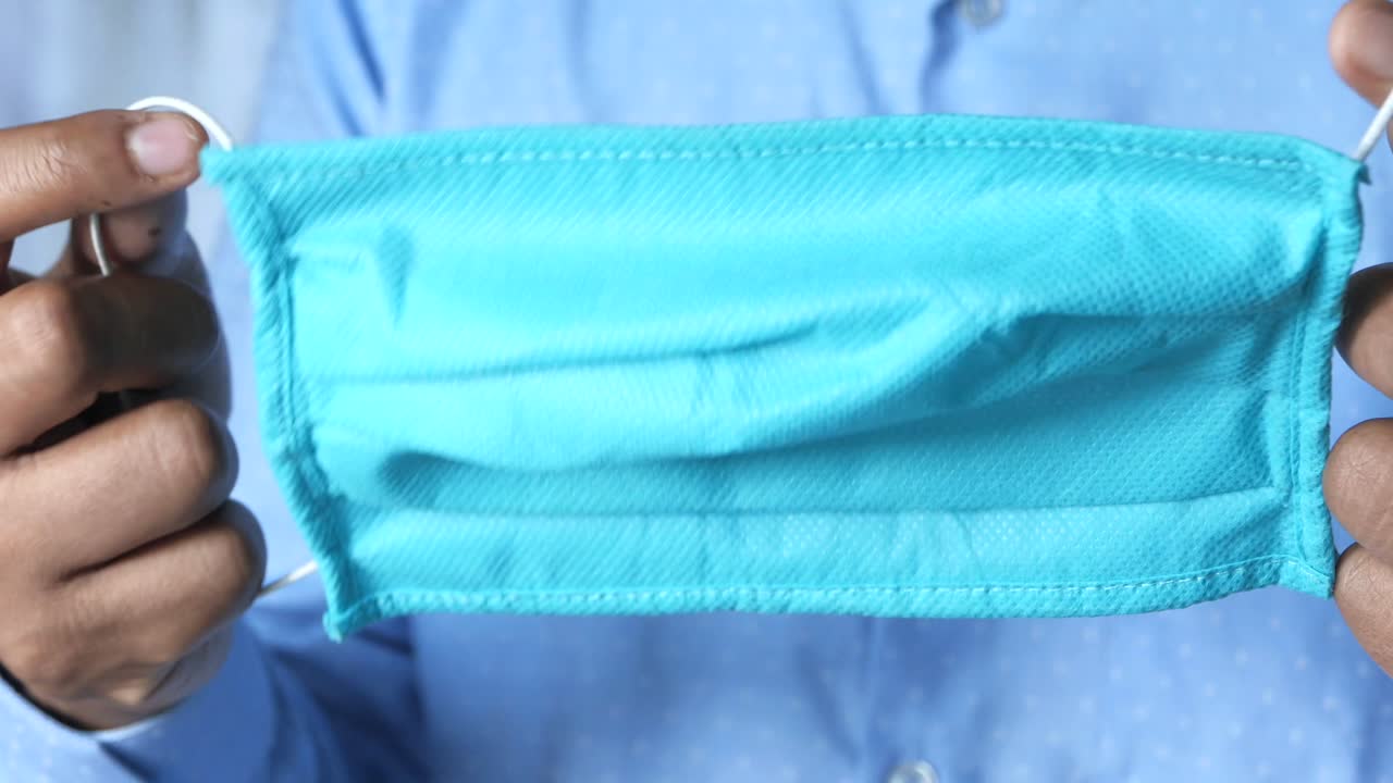 persona con una máscara quirúrgica azul