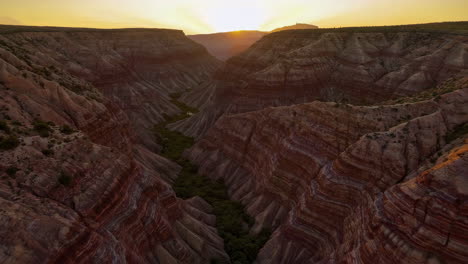 stunning canyon landscape with layered rock formations and riverbed at sunset