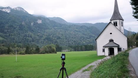 White-church-in-Slovenia-located-near-Mojstrana-on-an-overcast-day-with-green-fields-around