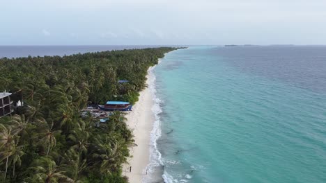hermoso resort de vacaciones de lujo en la isla de dhigurah maldives con océano turquesa y palmeras, drone al revés