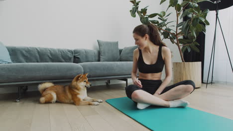 Ein-Mädchen-Macht-Eine-Pause-Von-Ihrer-Yogastunde,-Um-Mit-Ihrem-Süßen-Hund-Zu-Spielen