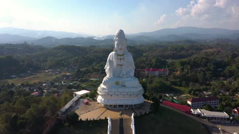 aerial de wat huay pla kang gigante estatua grande blanca y pagoda con montañas y espacio terrestre en chiang rai, tailandia