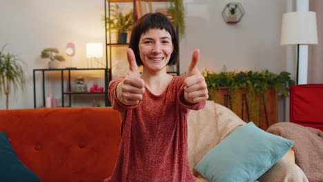excited caucasian woman looking approvingly at camera showing thumbs up like sign positive feedback