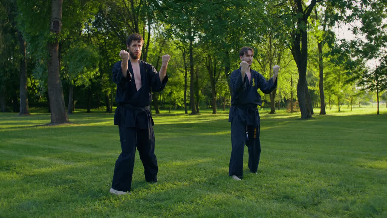 Due uomini che praticano karate all'aperto