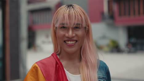 smiling transgender woman with rainbow flag