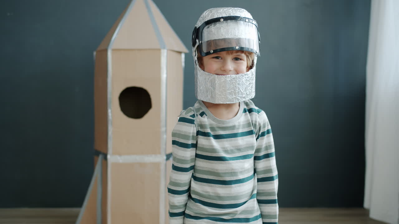 Child in astronaut costume with cardboard rocket