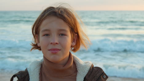 teen boy looking at camera by the ocean