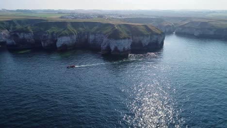 Beautiful-chalk-coastal-cliffs-at-low-tide,-with-visible-cracks-showing-in-the-cliff-faces