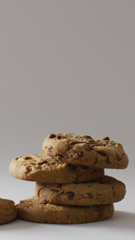 video of three stacks of chocolate chip cookies on pale grey background with copy space