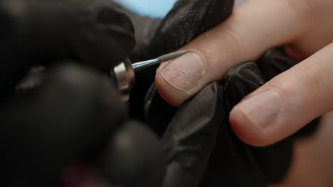 close-up of a nail technician filing a fingernail