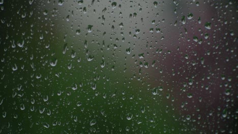 Ventana-Enfocada-Mientras-Las-Gotas-De-Lluvia-Caen-Sobre-Ella-En-El-Exterior-Desenfocado