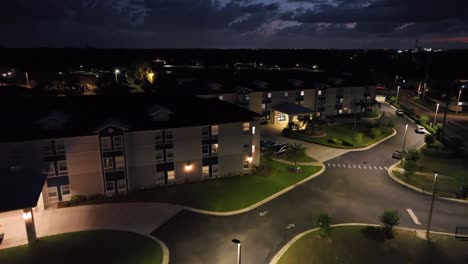 aerial approaching shot of luxury residential apartments with palm trees and thunderstorm at sky. lighting lantern in save community district of american town in plant city, florida.