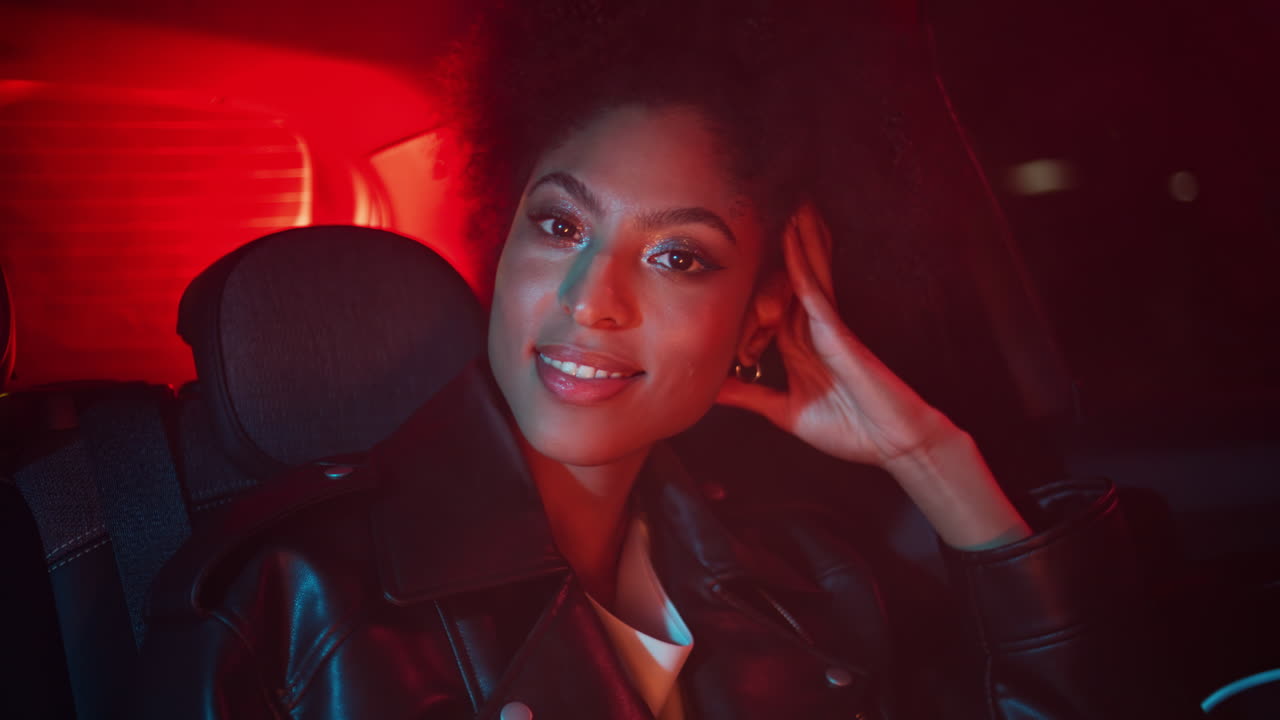 Woman sitting night auto looking camera smiling closeup. Portrait lady