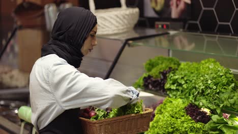 Dame-Im-Hijab-Füllt-Das-Frische-Grün-Im-Regal-Im-Supermarkt-Nach