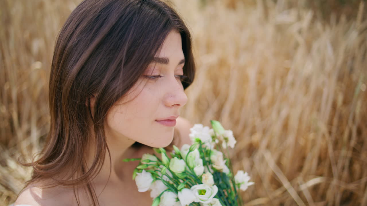 Young lady enjoying bloom flowers spikelets nature closeup. Woman looking camera