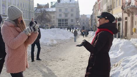 two friends enjoying a snowy day in a european city