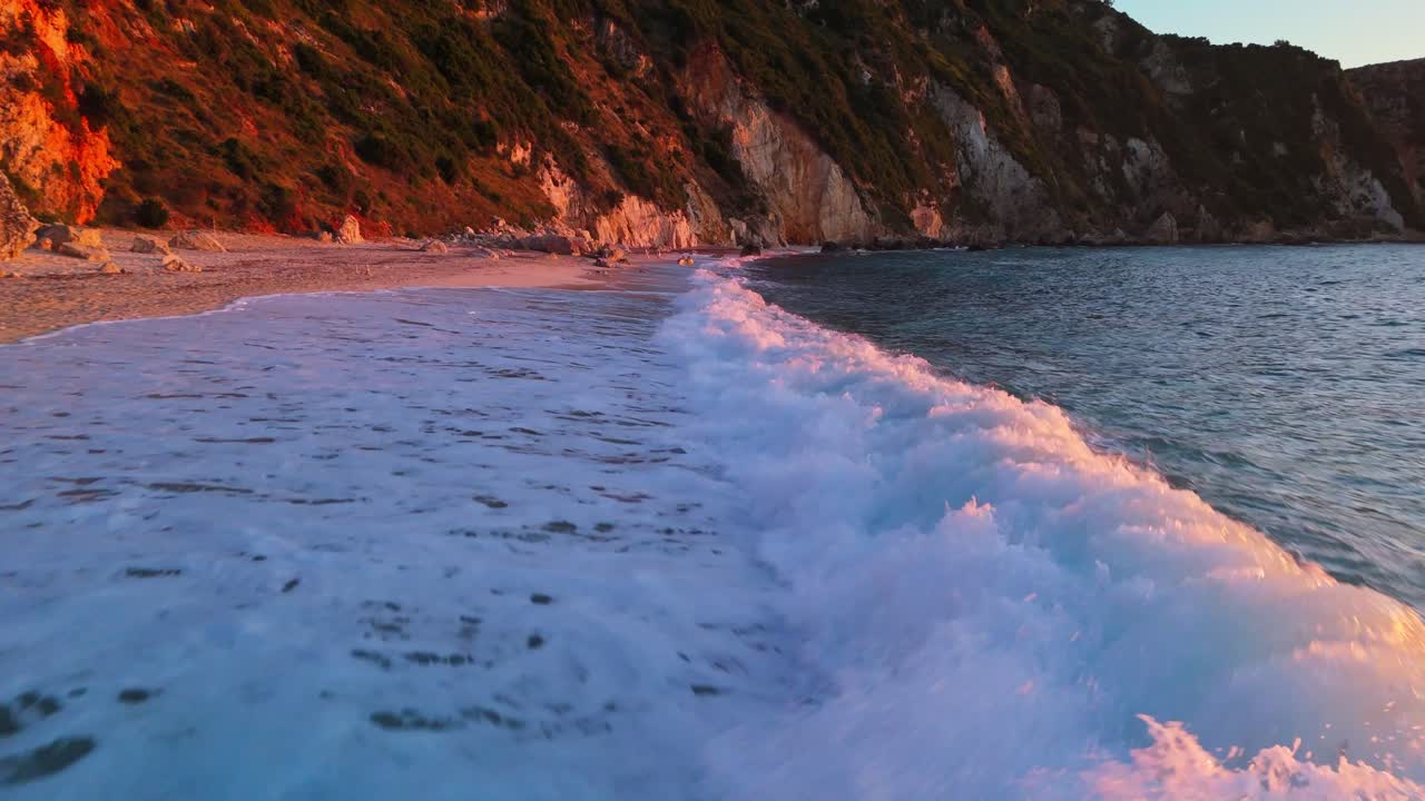 Beautiful aerial footage of sea waves gently rolling onto a pristine Greek beach. Captured in stunning 4K resolution, this drone video highlights the movement of turquoise water meeting golden sand,