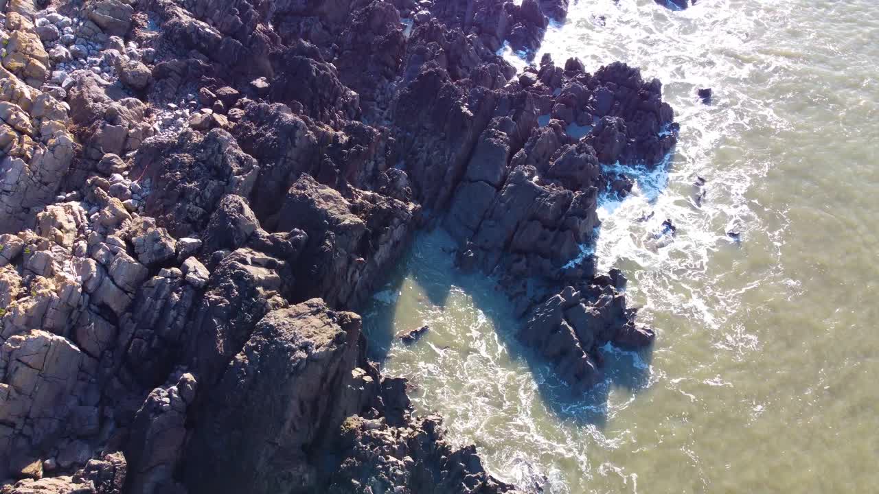 Fast Top Down Flying Over Rocky Coastline with Rugged Rocks and Rock Pools with Bright Sunshine. Travel Nature Drone Clip. Beautiful Welsh Gower Peninsula Coast