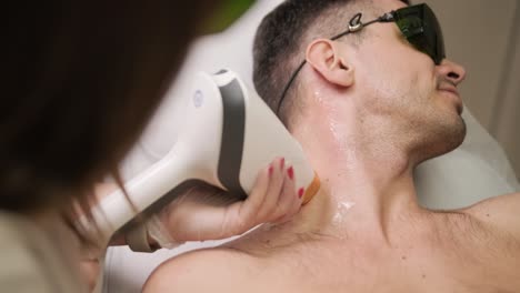 área del cuello del hombre durante el procedimiento de depilación láser en la clínica de cosmetología moderna. concepto de belleza del hombre, cosmetología, depilación