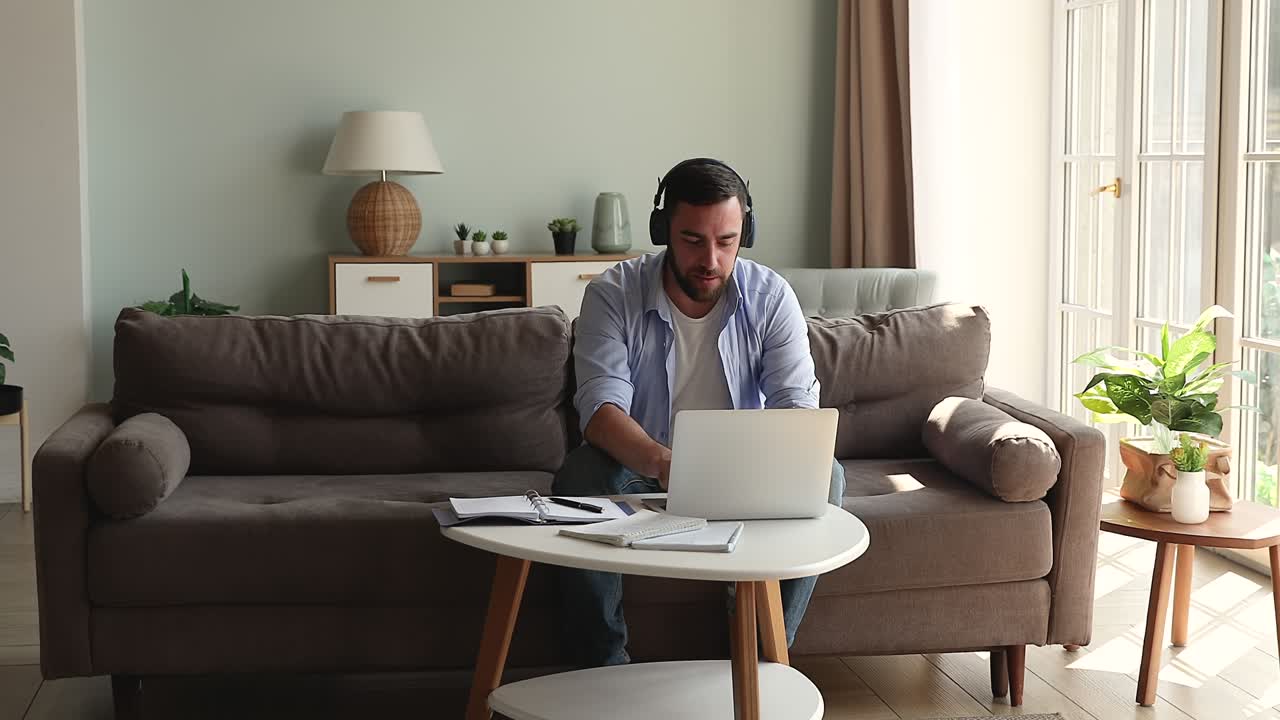 Young man in headset take part in conference using laptop