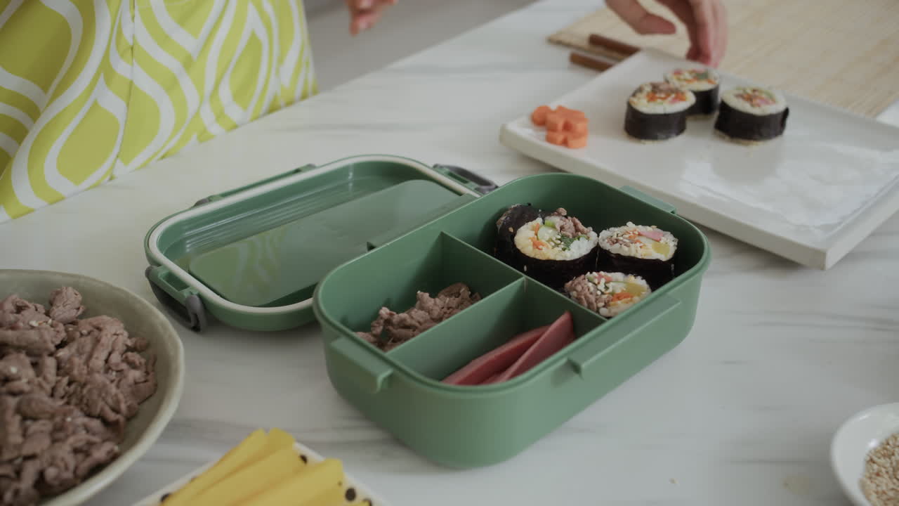 Anonymous Housewife Filling Lunchbox with Snacks and Kimbap