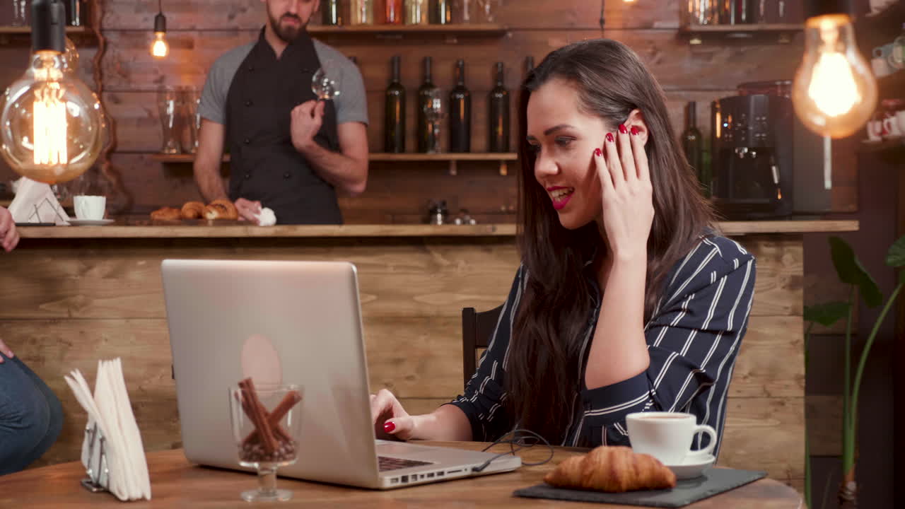 Kvinde på et videoopkald på en café